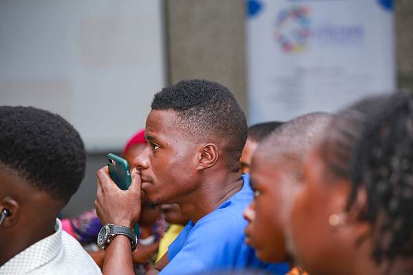 Young people sitting shoulder to shoulder, listening