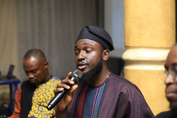 A man in a cap speaking into a microphone